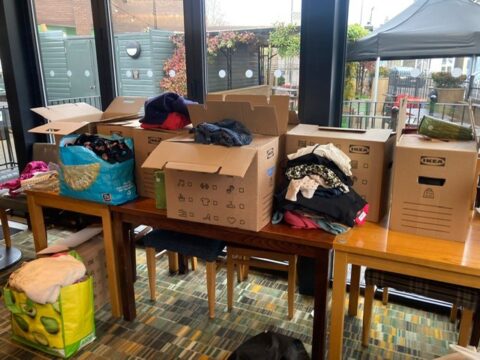 Photo showing tables with large number of boxes of clothing to be donated 